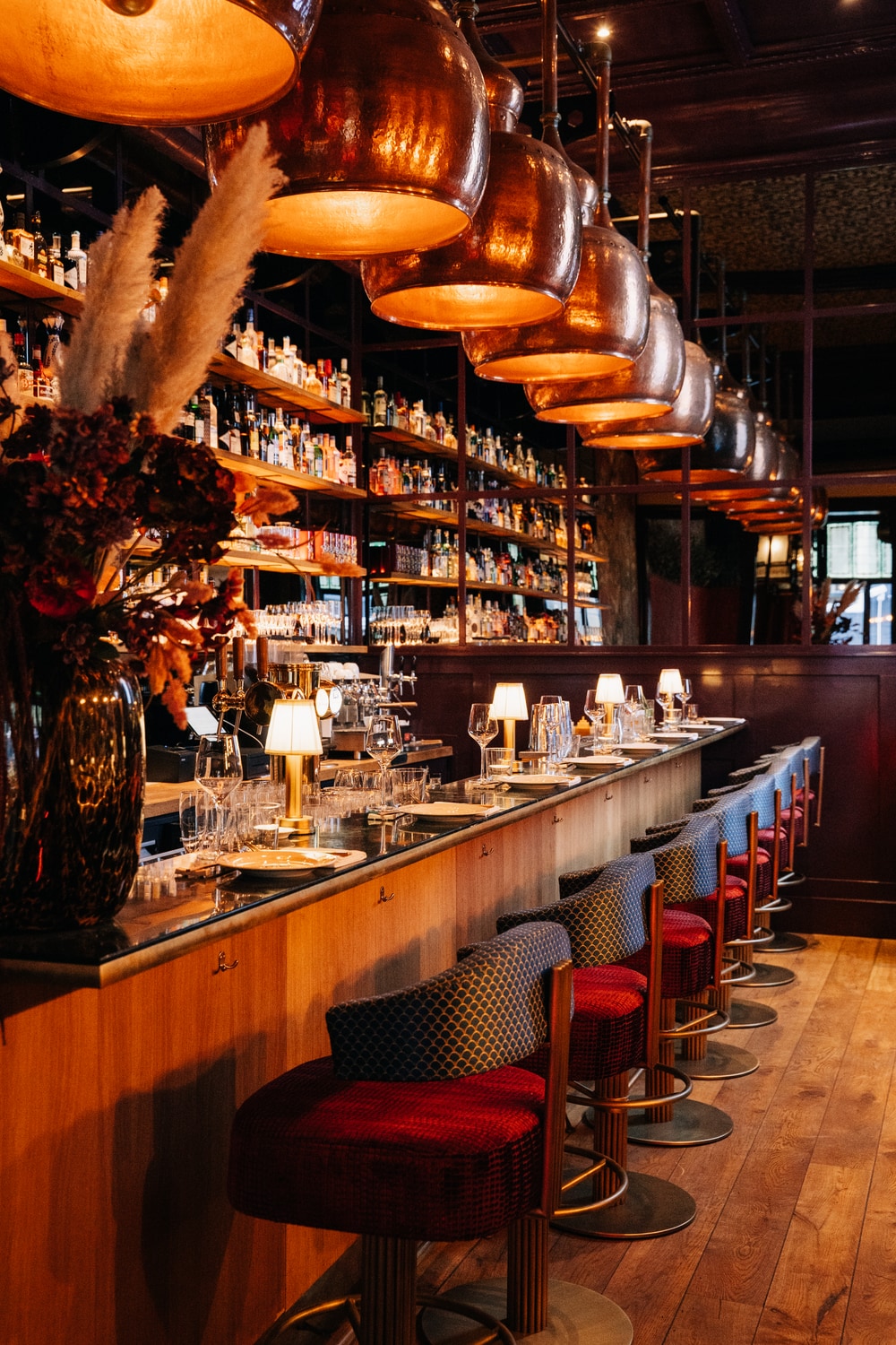 The long bar with copper shades and red bar stools