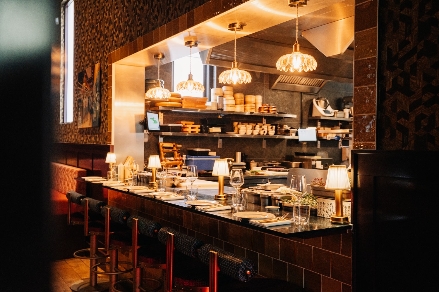 The open kitchen seen across the chef's table counter in warm light